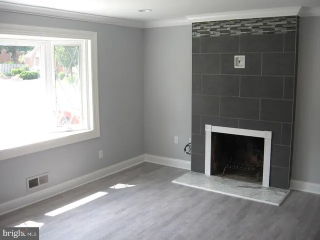 a view of an empty room with a fireplace and a window