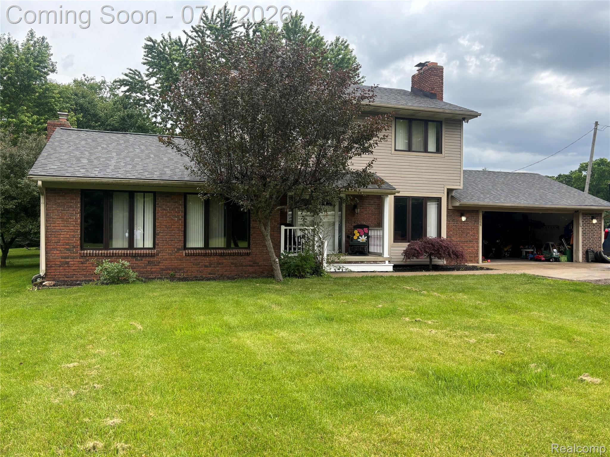 Brick and siding exterior with a multi-level roofline, featuring an attached two-car garage