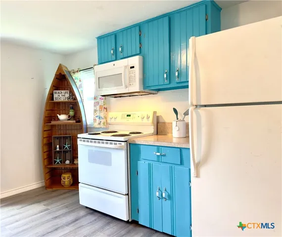 a kitchen with a refrigerator sink stove and cabinets