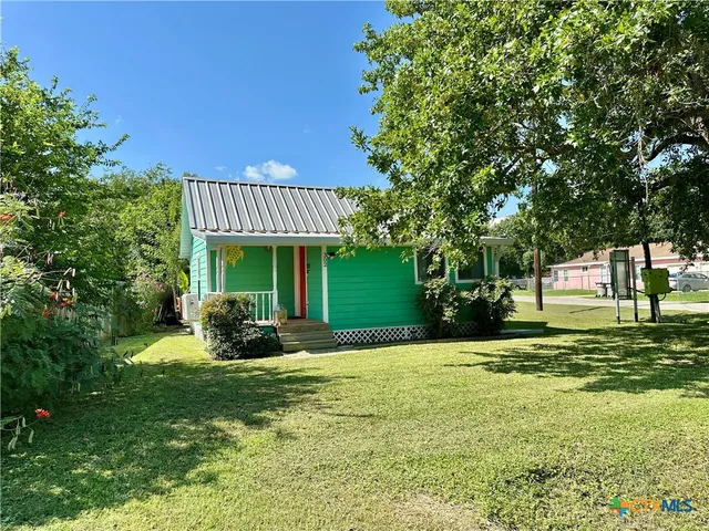a view of a house with a yard and sitting area