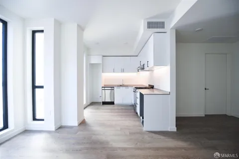 a kitchen with a sink cabinets and wooden floor