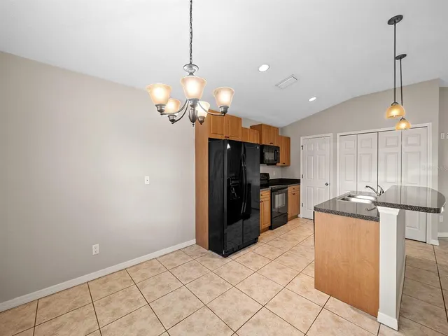 a kitchen with stainless steel appliances granite countertop a refrigerator a sink and a stove