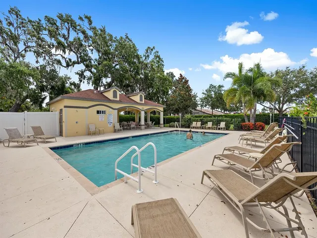 a view of a green field with tree in the background