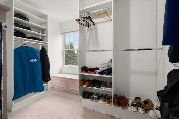 a view of walk in closet with clothes and shoes