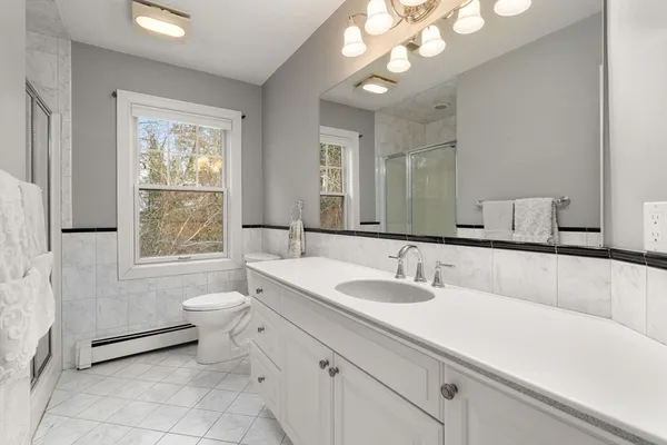 a bathroom with a sink a toilet and a mirror