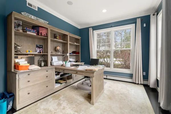 a view of a workspace with furniture and a window