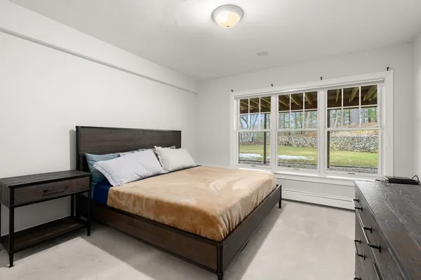 a large bed sitting in a bedroom next to a window