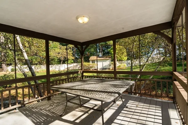 a view of a patio with a table chairs and wooden floor
