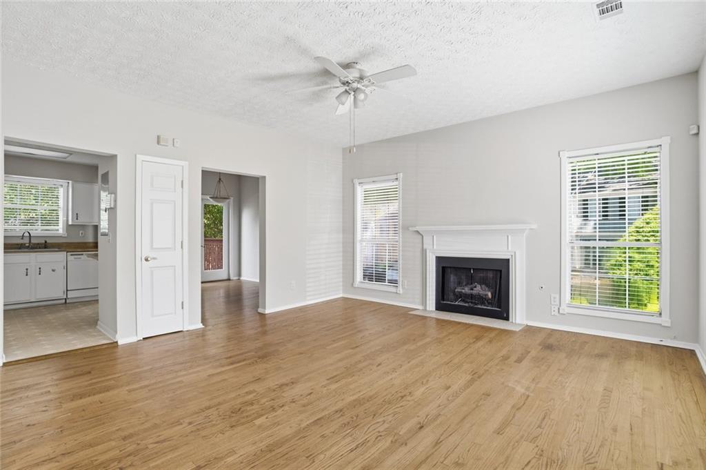 809 Wedgewood Way Atlanta, GA 30350 - Photo 2 of 27 an empty room with windows a fireplace and wooden floor
