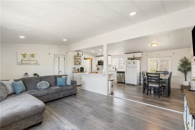 a living room with furniture and a dining table with kitchen view