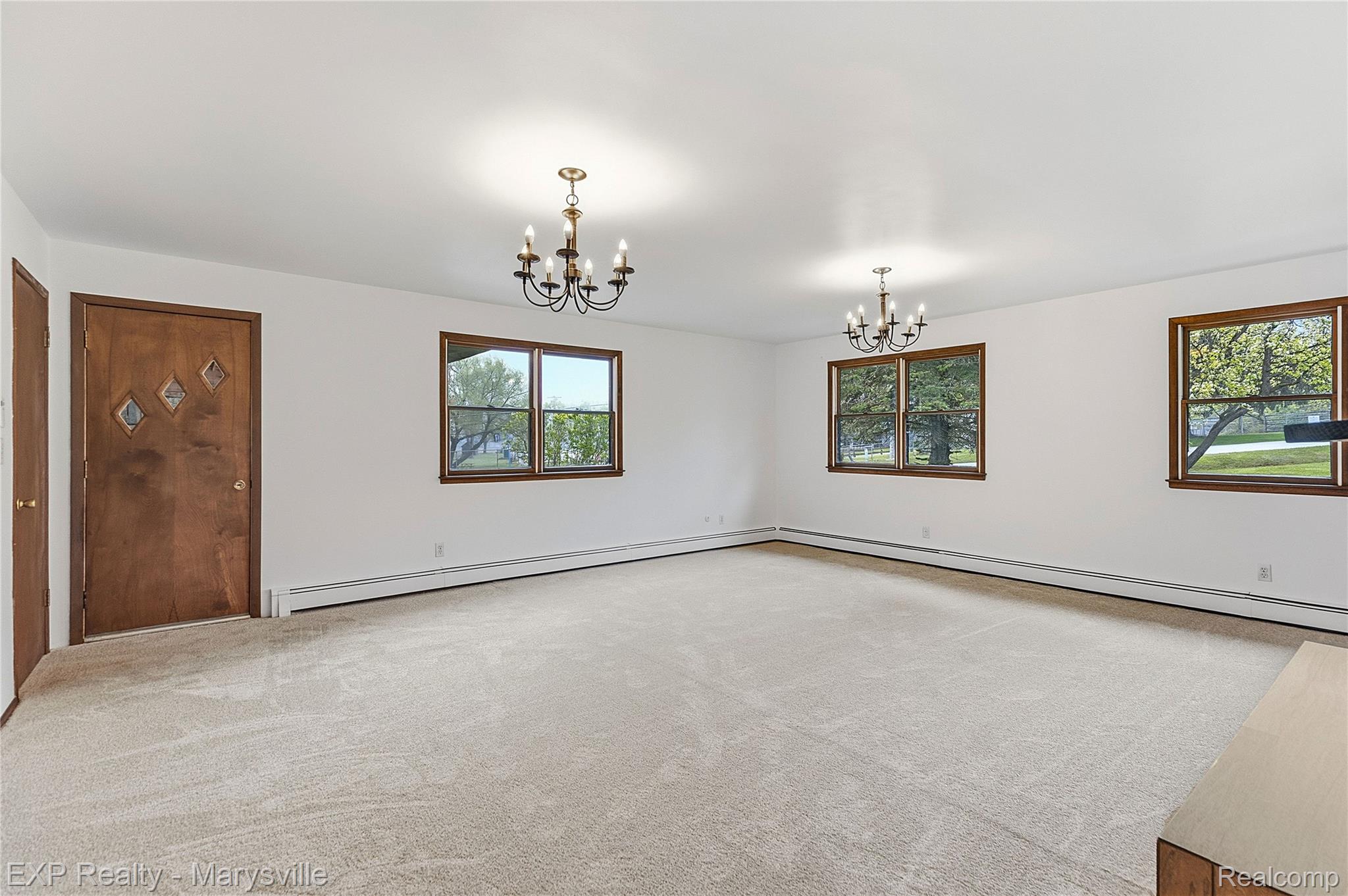 3345 Beach Road Port Huron, MI 48060 - Photo 6 of 89 Unfurnished room featuring a chandelier, light carpet, and a baseboard heating unit