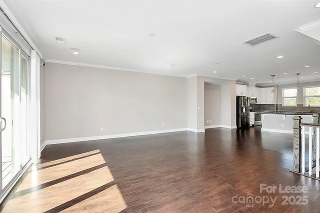 a view of empty room with wooden floor