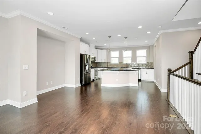 a view of kitchen with refrigerator stove and wooden floor