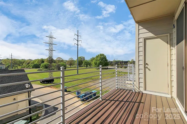a view of a balcony with floor to ceiling windows with wooden floor
