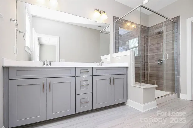 a bathroom with a double vanity sink a mirror and shower
