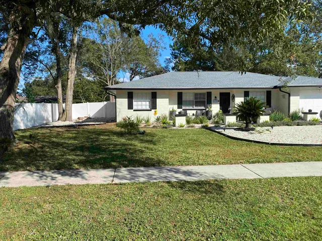 a front view of a house with a garden and yard