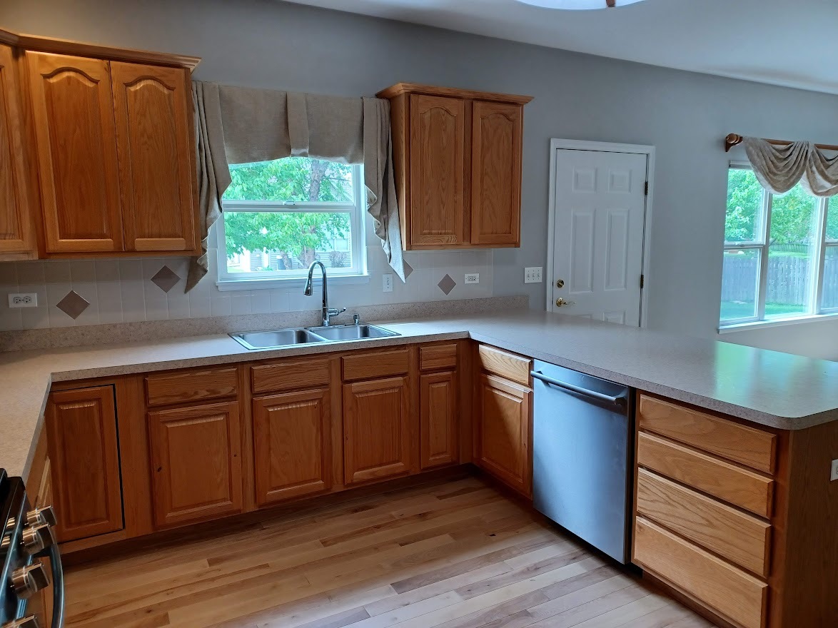 24463 Tufton Street Plainfield, IL 60585 - Photo 6 of 29 a kitchen with stainless steel appliances granite countertop wooden cabinets a sink and dishwasher with wooden floor