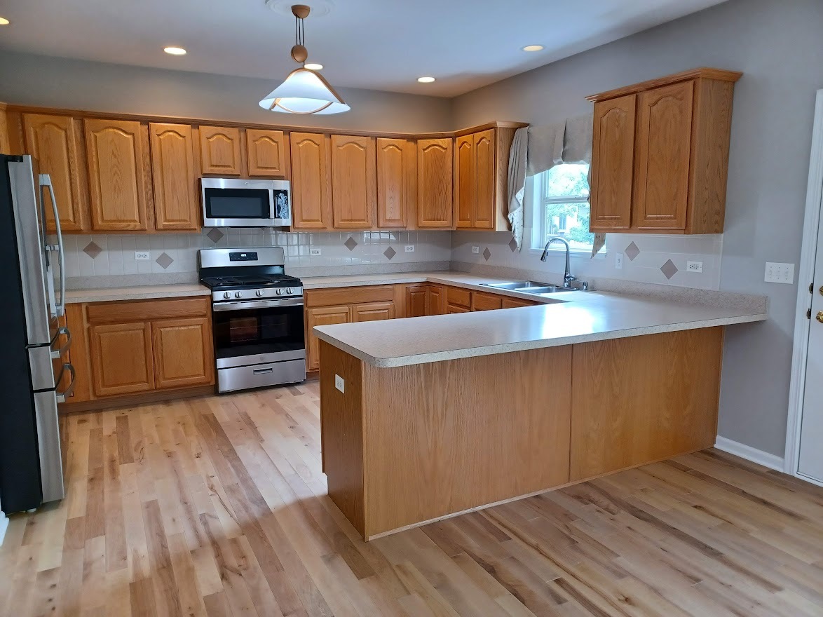 24463 Tufton Street Plainfield, IL 60585 - Photo 7 of 29 a kitchen with stainless steel appliances granite countertop wooden cabinets a stove a sink and dishwasher with wooden floor