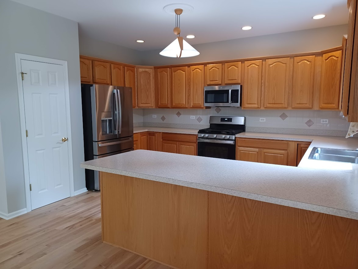 24463 Tufton Street Plainfield, IL 60585 - Photo 8 of 29 a kitchen with granite countertop a refrigerator stove top oven and sink