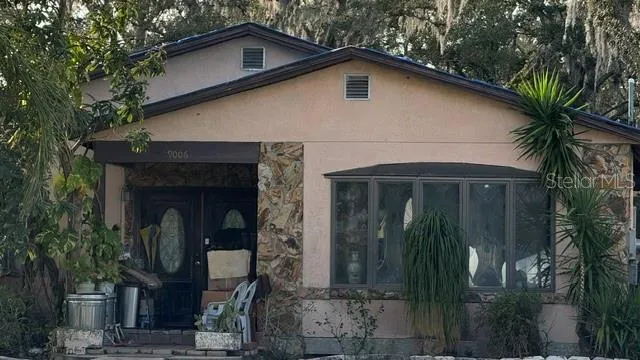 a front view of a house with plants