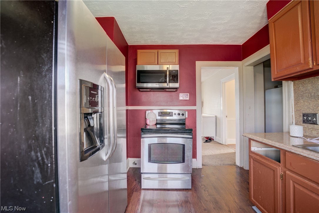 14202 Glenside Road Cleveland, OH 44110 - Photo 6 of 41 Kitchen with dark hardwood / wood-style flooring and appliances with stainless steel finishes
