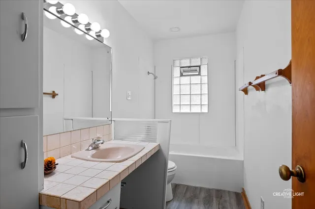 a bathroom with a sink double vanity granite tub shower and mirror