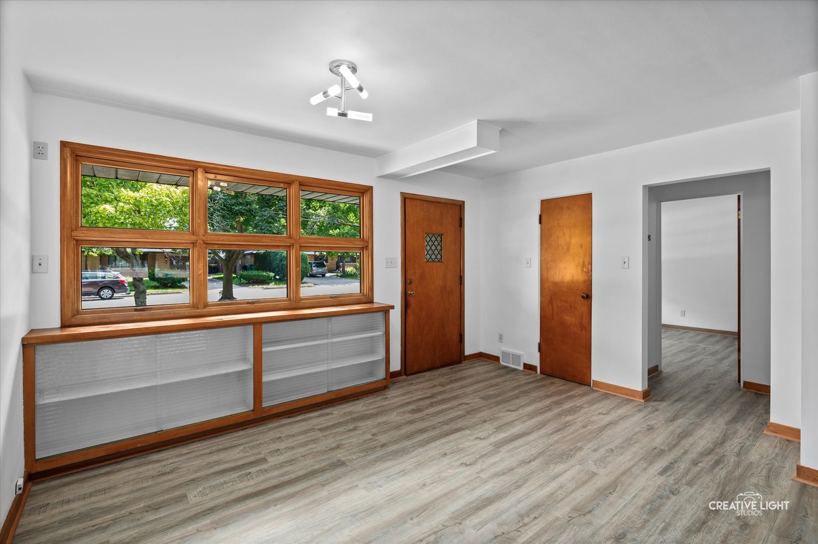 803 Alann Drive Joliet, IL 60435 - Photo 2 of 15 a view of an empty room with a window and wooden floor