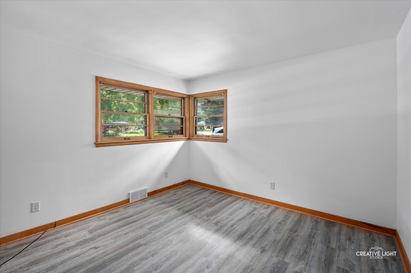 803 Alann Drive Joliet, IL 60435 - Photo 10 of 15 an empty room with wooden floor and windows