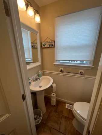 a bathroom with a sink a toilet a mirror and vanity