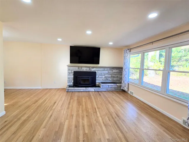 a view of empty room with wooden floor and fireplace