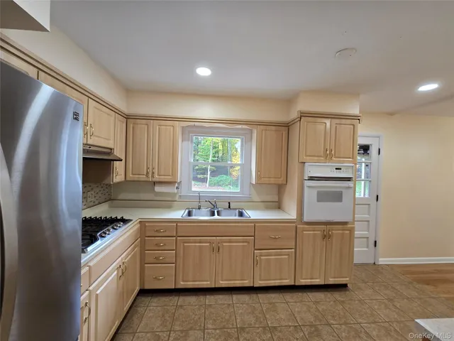 a kitchen with a sink window and cabinets