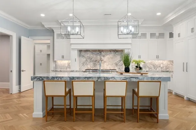 a kitchen with granite countertop white cabinets and chairs