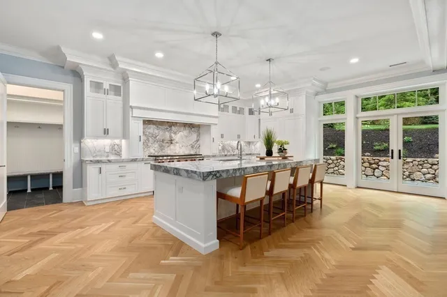 a kitchen with kitchen island granite countertop a table chairs sink and cabinets