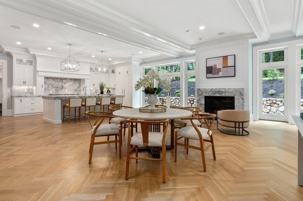 192 Pond Road Wellesley, MA 02482 - Photo 8 of 41 a dining room with furniture a fireplace a rug and kitchen view