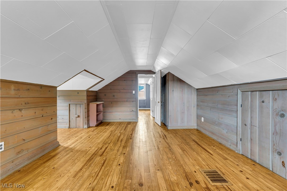 968 South Green Road Cleveland, OH 44121 - Photo 23 of 25 Additional living space featuring lofted ceiling, wood walls, and light hardwood / wood-style floors