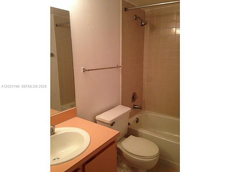 8260 Southwest 210th Street, Unit 319 Cutler Bay, FL 33189 - Photo 5 of 20 a bathroom with a granite countertop toilet sink and mirror