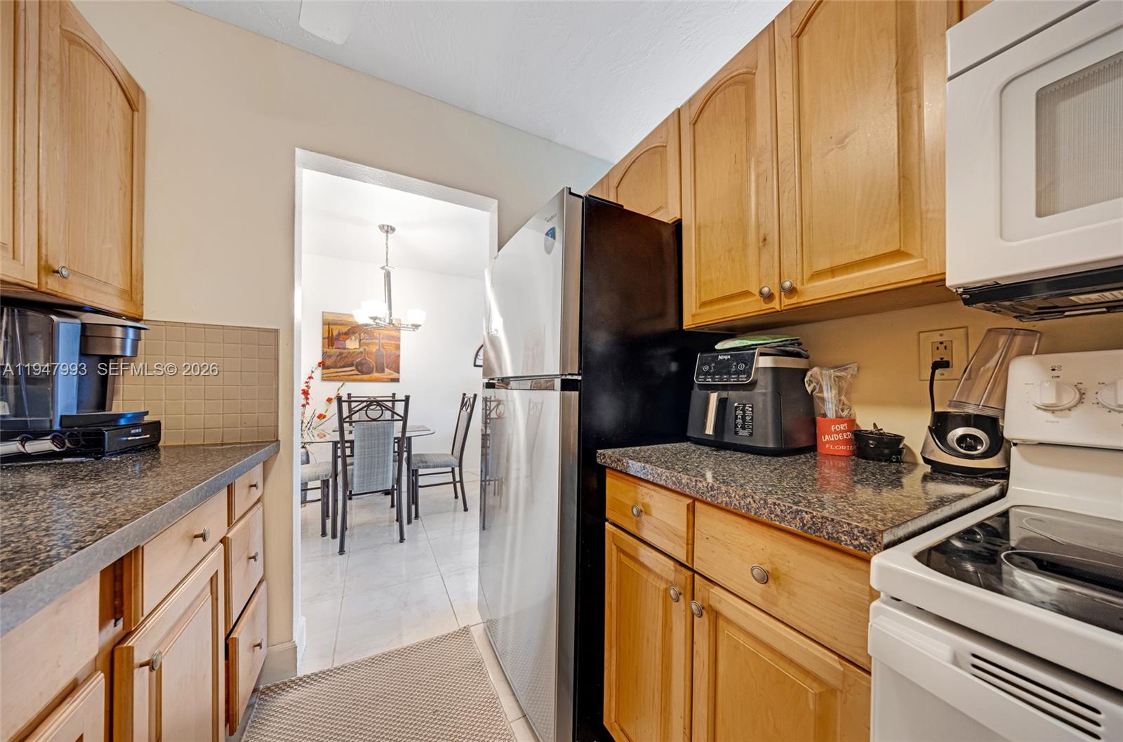 15610 Northeast 6th Avenue, Unit 9B Miami, FL 33162 - Photo 8 of 25 a kitchen with stainless steel appliances granite countertop a sink stove and cabinets