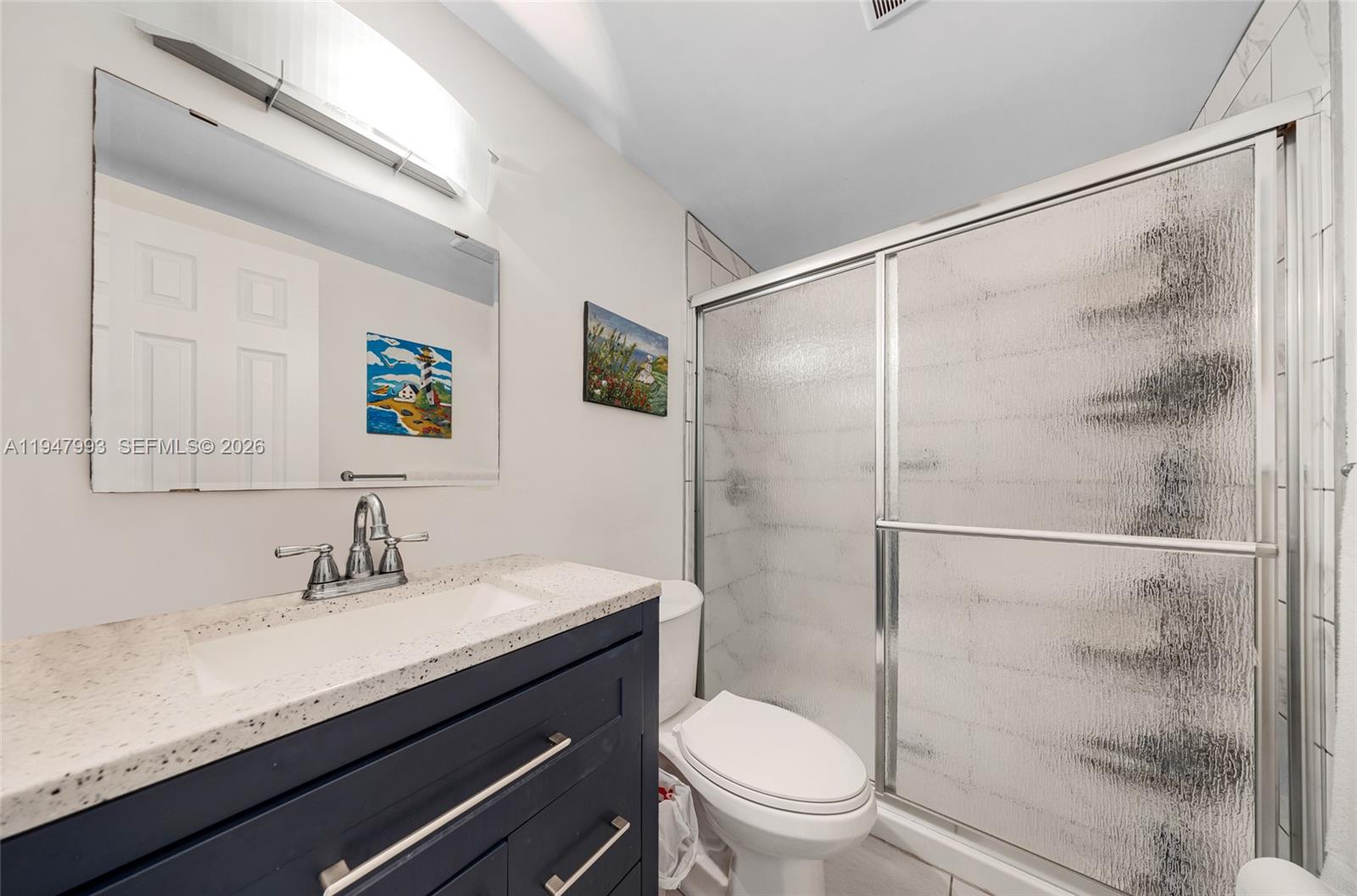 15610 Northeast 6th Avenue, Unit 9B Miami, FL 33162 - Photo 10 of 25 a bathroom with a granite countertop sink toilet and shower