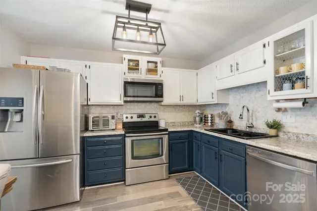 a kitchen with stainless steel appliances granite countertop a refrigerator sink and stove