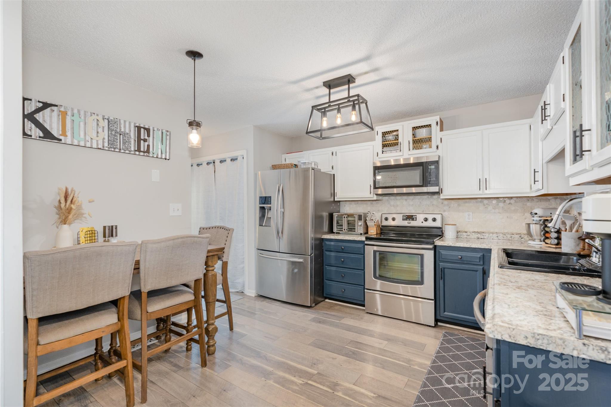 809 Fargo Drive Southwest Concord, NC 28027 - Photo 11 of 24 a kitchen with stainless steel appliances kitchen island granite countertop a table chairs microwave and cabinets