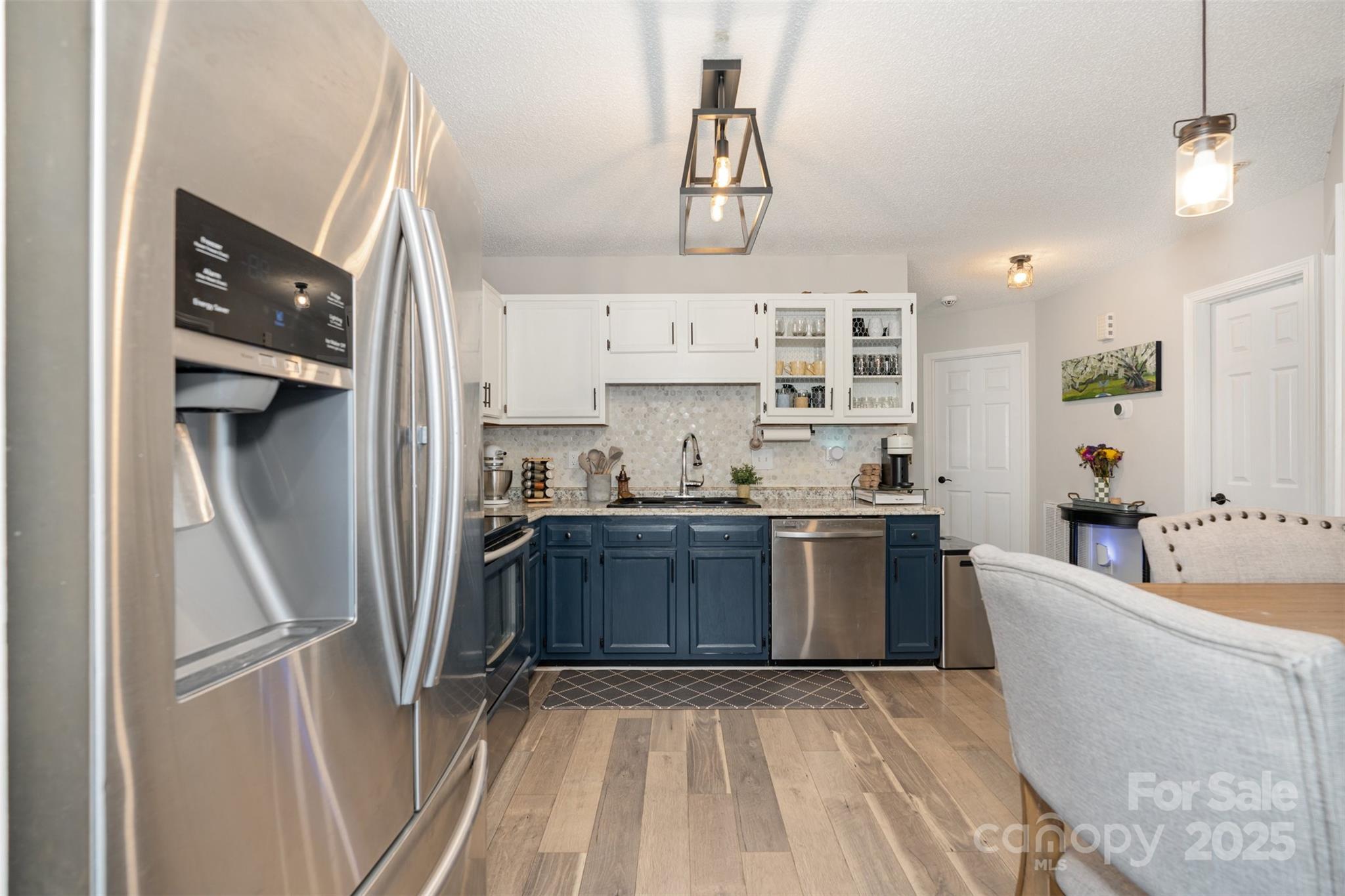 809 Fargo Drive Southwest Concord, NC 28027 - Photo 12 of 24 a kitchen with stainless steel appliances granite countertop a refrigerator a sink dishwasher a stove and white cabinets with wooden floor