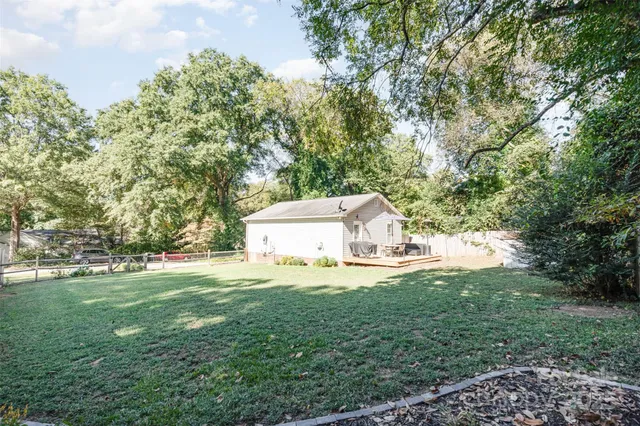 a white house with a big yard and large trees