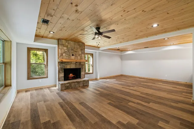 en empty room with windows and a fireplace