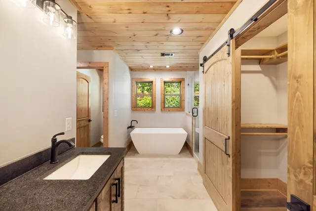 a bathroom with a sink double vanity mirror and bathtub