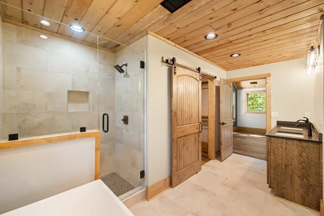 a bathroom with a sink a toilet a mirror and shower