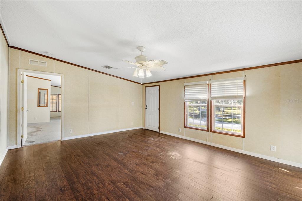 32443 Memory Lane Leesburg, FL 34788 - Photo 14 of 51 a view of an empty room with a window and wooden floor