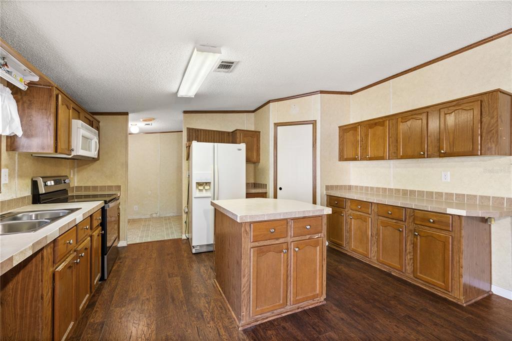 32443 Memory Lane Leesburg, FL 34788 - Photo 28 of 51 a kitchen with a stove top oven sink and cabinets