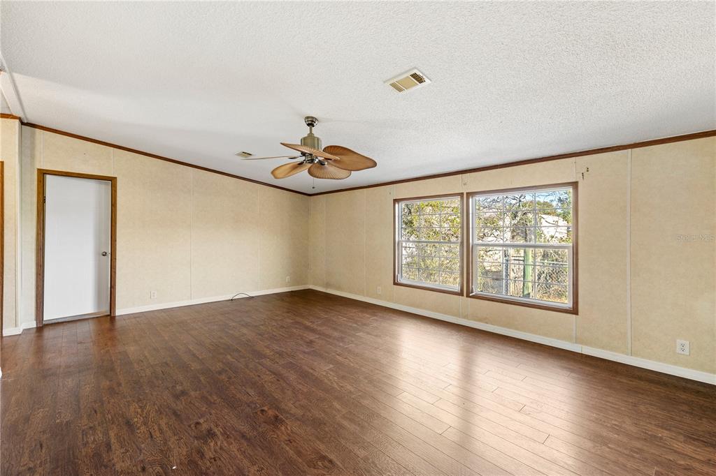 32443 Memory Lane Leesburg, FL 34788 - Photo 31 of 51 a view of an empty room with wooden floor and a window