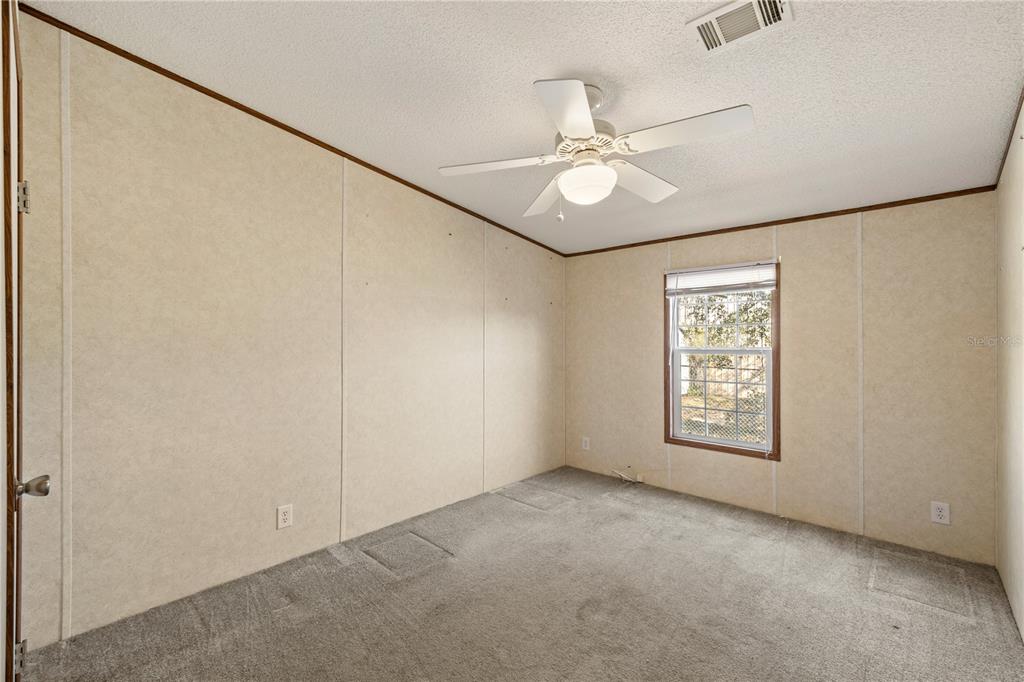 32443 Memory Lane Leesburg, FL 34788 - Photo 34 of 51 an empty room with windows and fan