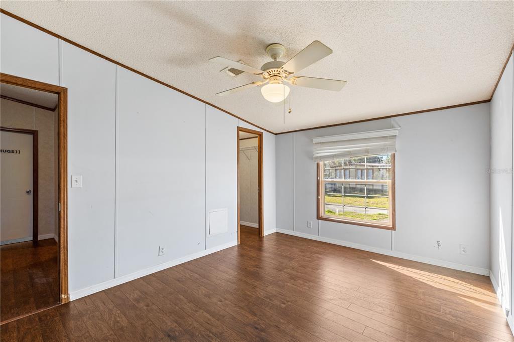 32443 Memory Lane Leesburg, FL 34788 - Photo 36 of 51 an empty room with wooden floor fan and windows